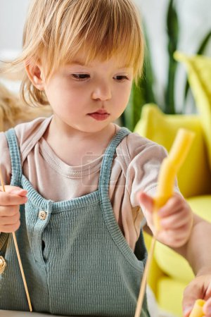Little girl holding dry pasta and exploring sensory game