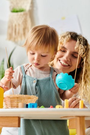 Téléchargez les photos : Une mère bouclée et sa petite fille jouent avec des jouets inspirés de Montessori à la maison, favorisant la créativité et l'apprentissage. - en image libre de droit