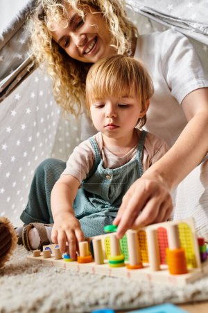 A curly mother and her toddler daughter engage in the Montessori method, playing with colorful blocks at home.