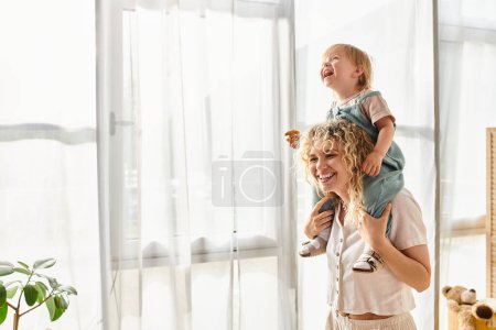 A curly-haired mother tenderly holds her toddler daughter in her arms, expressing love and care at home.