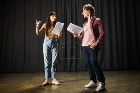 Un hombre y una mujer revisan los papeles juntos durante los ensayos de teatro.