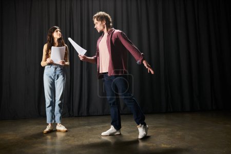 A man and woman practicing lines together, holding a paper.