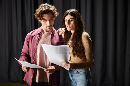 A man and woman study a script together.