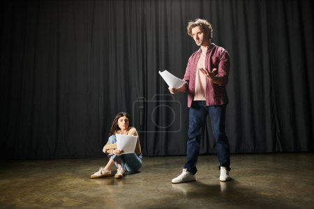 Elegante hombre y mujer de pie juntos en un escenario teatral.
