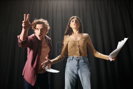 Foto de Handsome man and woman stand elegantly together, rehearsing for a theater performance. - Imagen libre de derechos