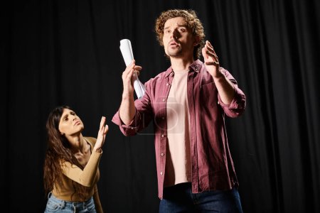 Un hombre con estilo se presenta delante de una mujer durante los ensayos de teatro.