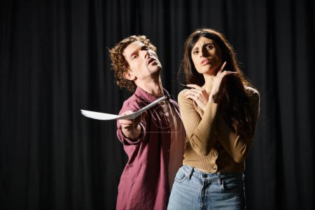 A man and woman rehearsing a dramatic scene, she holds a knife.