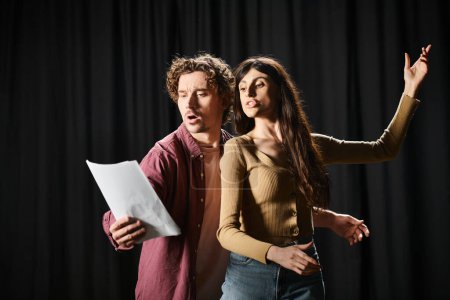 Photo for A man and woman rehearsing together with a paper in hand. - Royalty Free Image