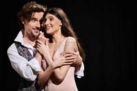 Foto de Un hombre guapo y una mujer hermosa comparten un abrazo sincero durante los ensayos de teatro. - Imagen libre de derechos