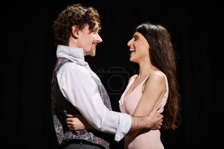 A good-looking man and woman rehearse together in a theater.