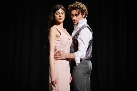 Téléchargez les photos : Beau homme et femme en robe rose répétant pour un spectacle de théâtre. - en image libre de droit