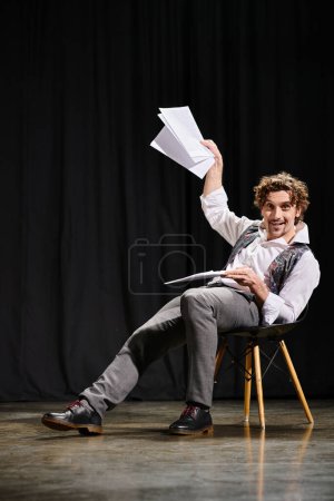 Photo for A man in a chair, absorbed, holding a paper. - Royalty Free Image