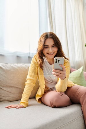 Middle aged woman enjoying a calm moment on a couch, engaged with her cell phone.