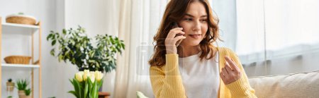 Photo for Middle-aged woman sitting on a couch, engrossed in a phone conversation. - Royalty Free Image