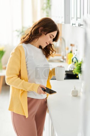 Middle aged woman enjoying a cup of coffee at the kitchen counter.