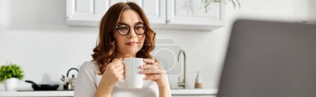 Téléchargez les photos : Femme d'âge moyen profitant d'un moment calme avec son café. - en image libre de droit