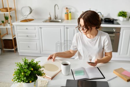 A middle-aged woman enjoys a book and coffee at a table.