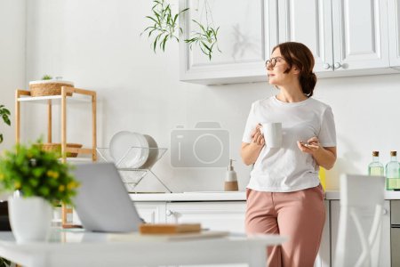 Mujer de mediana edad de pie frente a la computadora portátil.