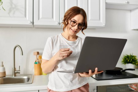 Middle-aged woman looking at a laptop.