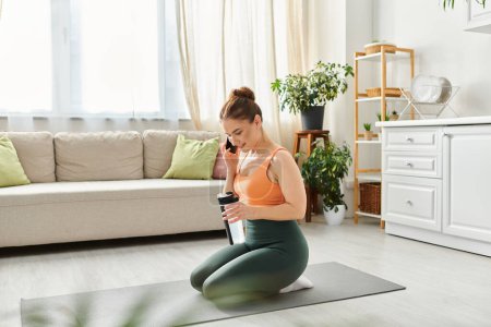 Téléchargez les photos : Femme d'âge moyen sur tapis de yoga, conversant sur téléphone portable. - en image libre de droit