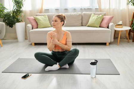 Frau mittleren Alters praktiziert Yoga auf einer Matte in ihrem Wohnzimmer.