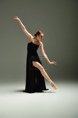 A young, beautiful ballerina in a black dress dances gracefully.
