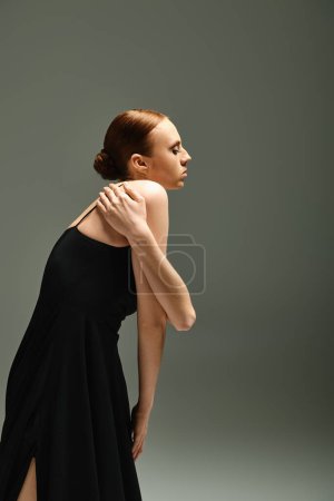 Téléchargez les photos : A young, beautiful ballerina in a black dress strikes a pose for a photograph. - en image libre de droit