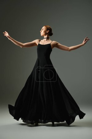 A young beautiful ballerina in a black dress dances elegantly.