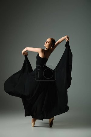 Una bailarina joven y hermosa en un vestido negro baila con gracia.