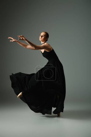 Young, beautiful ballerina in a black dress dances gracefully.