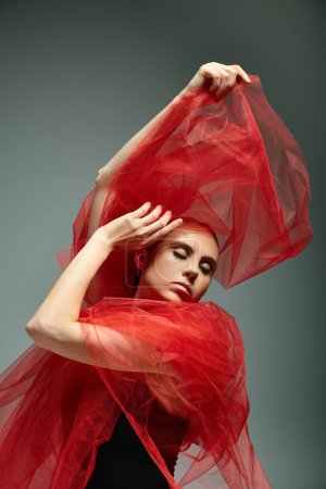 Foto de Una hermosa bailarina joven en un chal rojo baila con gracia. - Imagen libre de derechos