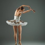 Talented ballerina strikes a graceful pose in a white tutu.