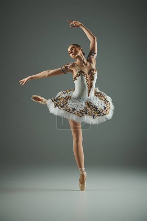 A young, talented ballerina in a white tutu and dress dances gracefully.