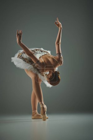 Photo for Ballerina in white tutu performs handstand with grace and skill. - Royalty Free Image