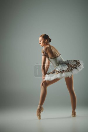 Talented ballerina poses in white dress.