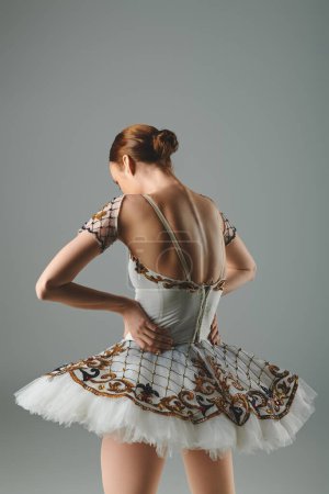 Young ballerina gracefully performing in a white and gold dress.
