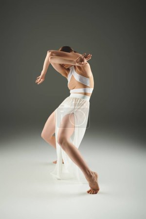 Téléchargez les photos : A young, beautiful ballerina in a white dress dances gracefully. - en image libre de droit