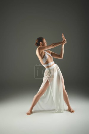 Foto de Elegante bailarina en vestido blanco golpea una pose - Imagen libre de derechos