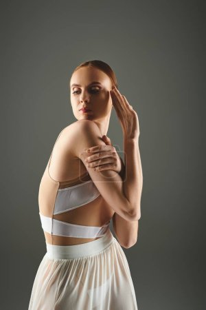 A graceful ballerina in a white dress striking a pose.