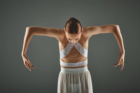 Foto de Young ballerina in white dress stretching gracefully. - Imagen libre de derechos