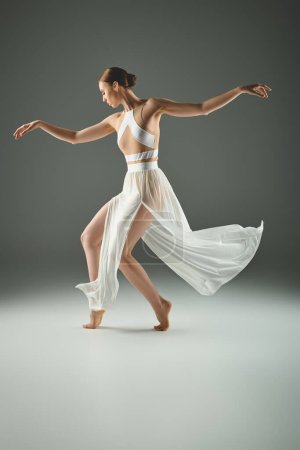 Photo for A young beautiful ballerina energetically dancing in a white dress. - Royalty Free Image