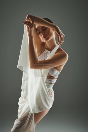 Una joven bailarina en un vestido blanco cautiva con su elegante velo de baile.