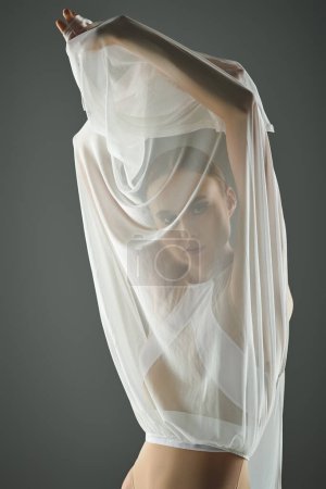 Eine junge, schöne Ballerina in einem hauchdünnen weißen Kleid mit Schleier, die anmutig tanzt.