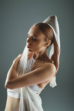 A ballerina in a white dress holds her head.