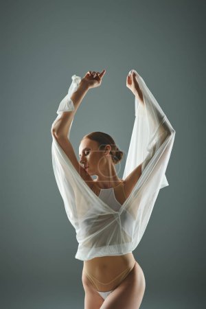 Joven hermosa bailarina en camisa blanca muestra su talento de baile.