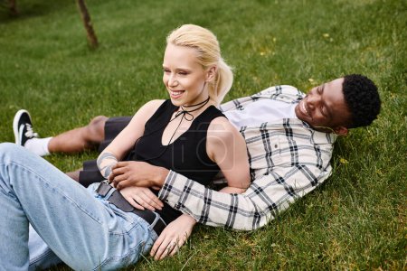 Ein multikulturelles Paar, ein afroamerikanischer Mann und eine kaukasische Frau, genießen einen friedlichen Moment gemeinsam auf dem Rasen.