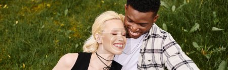 Téléchargez les photos : Un couple multiculturel heureux, un homme afro-américain et une femme blanche, debout l'un à côté de l'autre à l'extérieur dans un parc. - en image libre de droit