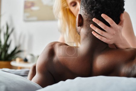 Un hombre sin camisa yace en una cama, exudando una sensación de vulnerabilidad y tranquilidad.