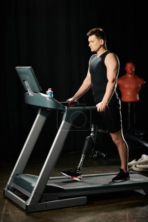 A man with a prosthetic leg stands on a treadmill in a dark room, pushing himself to keep going.