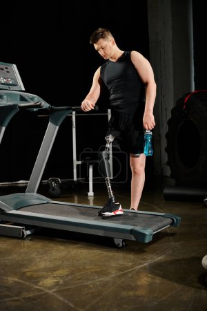 A disabled man with a prosthetic leg is standing and exercising on a treadmill in a dimly lit room.